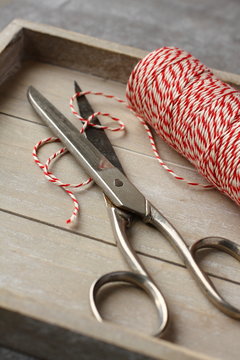 Scissors and spool of thread on wooden tray