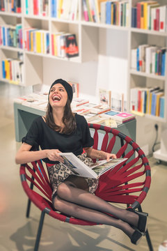 Beautiful young brunette sitting in a bookstore