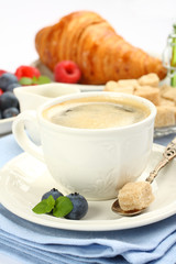 Breakfast with cup of coffee, croissants and berries