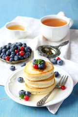 Stack of pancakes with fresh berries and honey