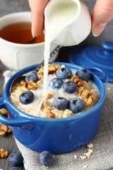 Oatmeal with fresh blueberries over a rustic wooden background