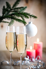 Glasses of champagne under decorated christmas tree branch
