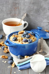Oatmeal with fresh blueberries over a rustic wooden background
