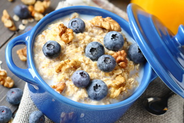 Oatmeal with fresh blueberries over a rustic wooden background