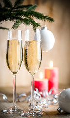 Glasses of champagne under decorated christmas tree branch