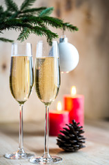 Glasses of champagne under decorated christmas tree branch
