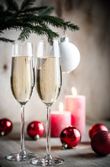 Glasses of champagne under decorated christmas tree branch
