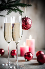 Glasses of champagne under decorated christmas tree branch