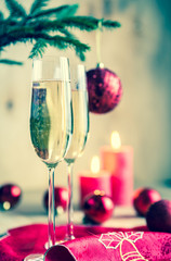 Glasses of champagne under decorated christmas tree branch
