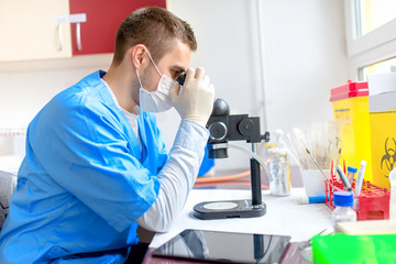 male chemist working with microscope in laboratory