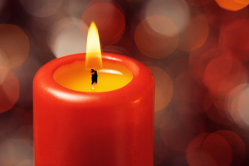 Macro of red candle with fire against defocused lights