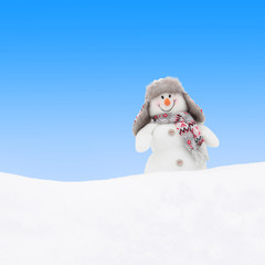 Happy winter snowman at white snow against blue sky