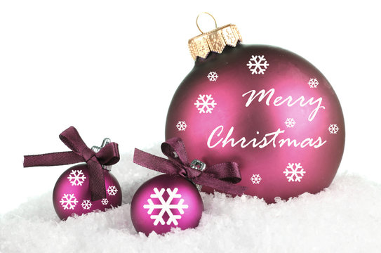 Beautiful purple Christmas balls on snow, isolated on white