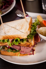 Delicious pastrami club sandwich and pickles