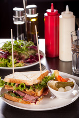 Delicious pastrami club sandwich and pickles