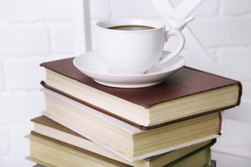 Old books and cup of coffee on table