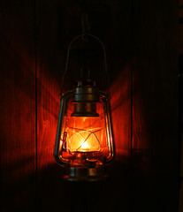 Lantern hanging on hook on wooden wall