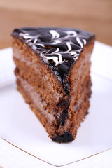 Delicious chocolate cake on plate on table close-up