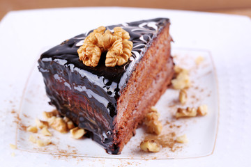 Delicious chocolate cake on plate on table close-up