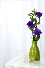 Beautiful bouquet of flowers in vase on window background