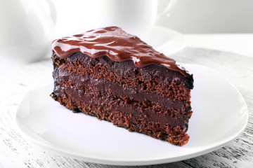Delicious chocolate cake on plate on table on light background