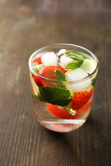 Summer cocktail with ice cubes on wooden table
