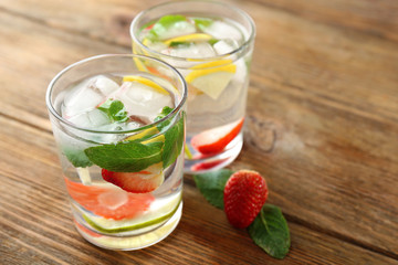 Summer cocktail with ice cubes on wooden table