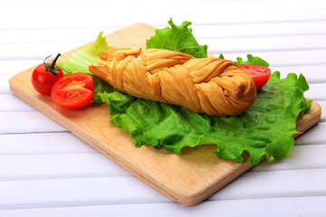 Smoked braided cheese on wooden table