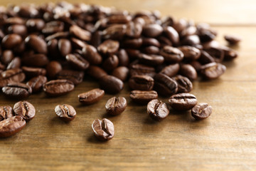 Naklejka premium Coffee beans on wooden background, close-up