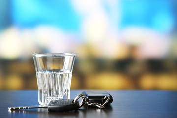 Glass of alcoholic drink and car key,