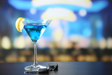 Glass of alcoholic drink and car key,