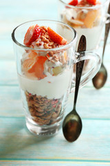 Healthy layered dessert with muesli and strawberries on table