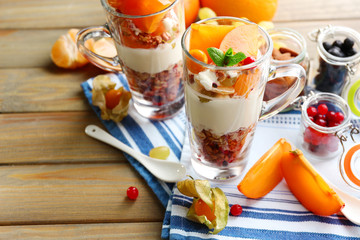 Healthy layered dessert with muesli and fruits on table