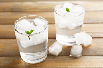 Glasses with ice cubes on wooden table