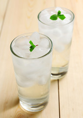 Glasses with ice cubes on wooden table