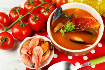 Tasty soup with shrimps, mussels, tomatoes and black olives in
