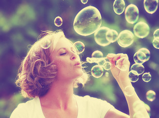 a beautiful woman blowing bubbles