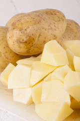 Whole Potatoes and Chopped Pieces on Cutting Board