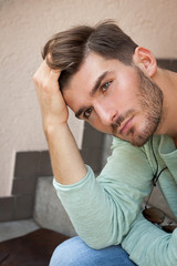 Casual  young man sitting on steps