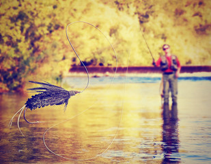 a person fly fishing with a big trout in front
