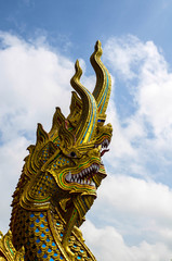 Fototapeta na wymiar Golden Naga Statue with blue sky
