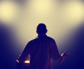 a young man in front of a podium and an audience