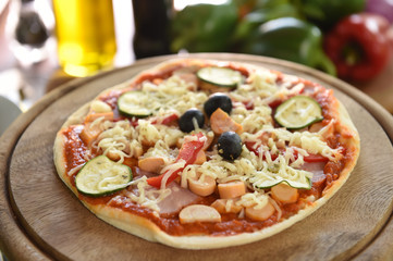 pizza and vegetables on wooden board.