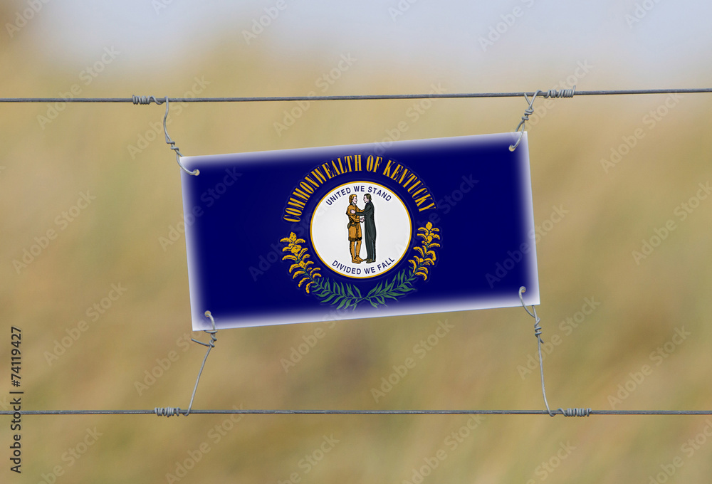 Wall mural border fence - old plastic sign with a flag