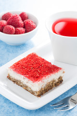 cream cakes with raspberry and fruit tea, vertical