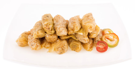 rolles of vabbage leaves stuffed with rice in a white plate isol