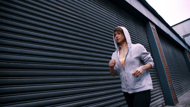 Focused Woman Running and Listening To Music