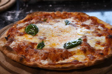 close up of pizza on wooden board.
