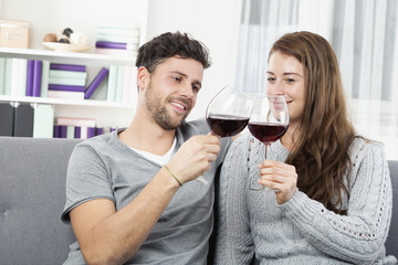 Junges Pärchen trinkt zuhause Rotwein