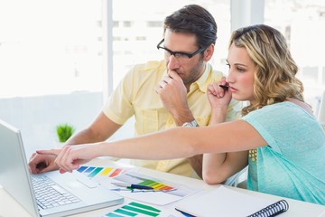 Creative design team during brainstorming working on laptop